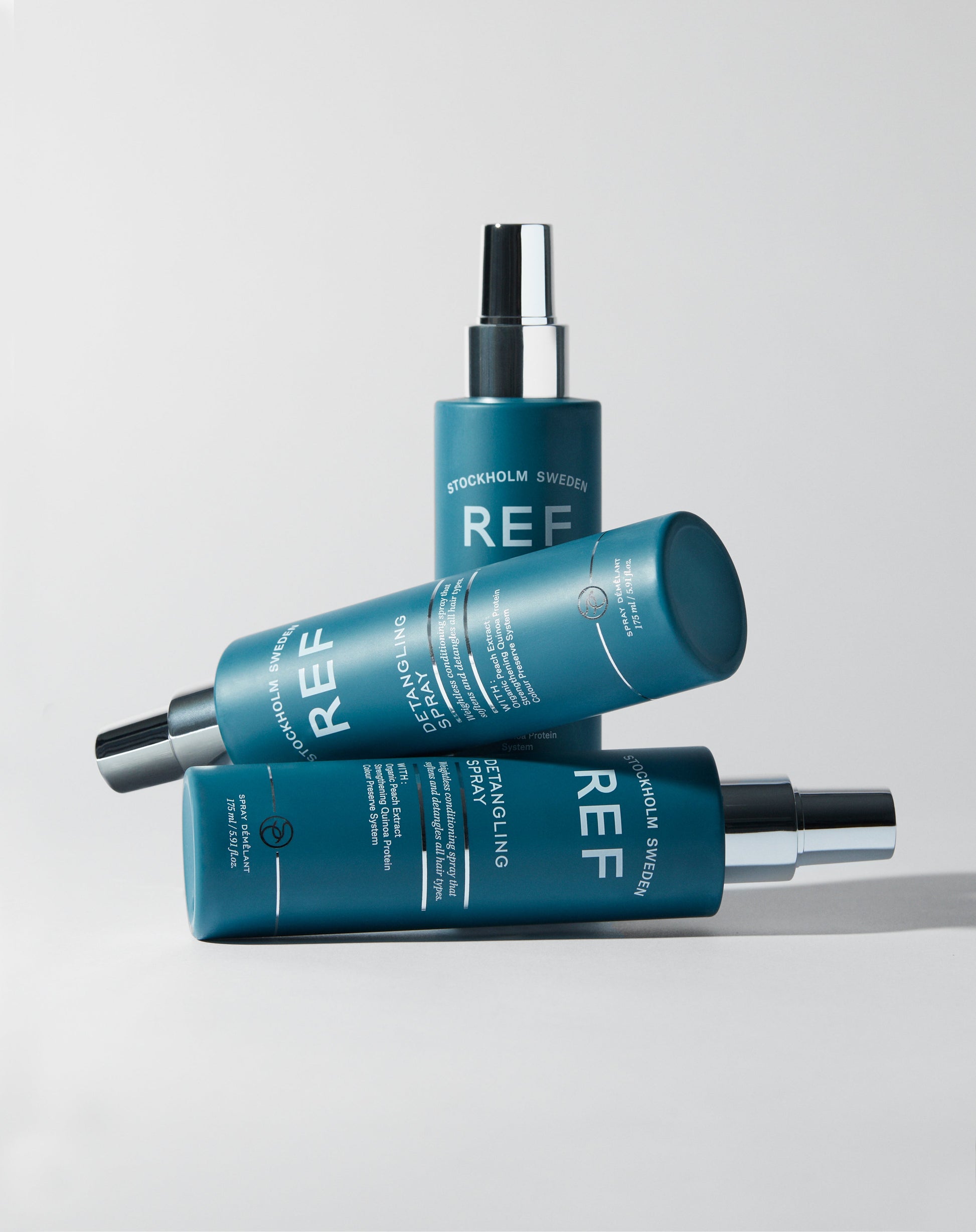 lifestyle image of 3 bottles REF Stockholm  Detangling Spray 175ml